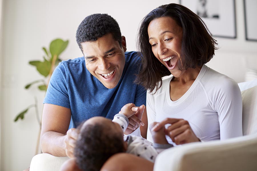 Personal Insurance - New Parents Gaze at Their Newborn Baby in Their Kitchen